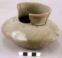Small squat pottery jar with fragments inside