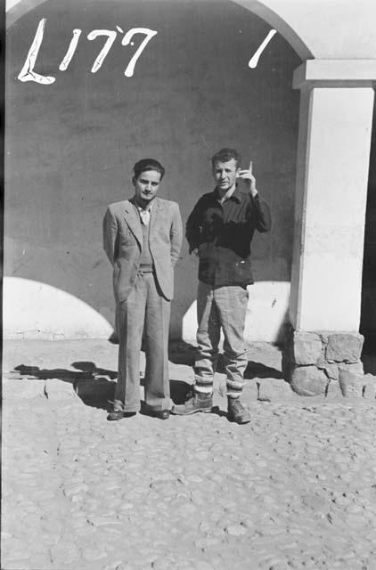 Unidentified men standing by archway