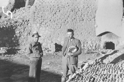 Unidentified men standing near wall