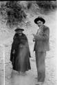 Unidentified man and elderly woman on the road