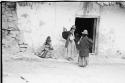 Women and children standing near doorway