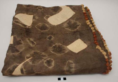 Kuba skirt, background of resist-dye with applique geometric patterns, fringed edges. Unique, early example. Minor holes, thinning fabric, separation of border near one end. Minor staining visible on tan geometric areas.