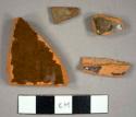 Redward sherds with lead glaze on the interior; one rim sherd to a small bowl