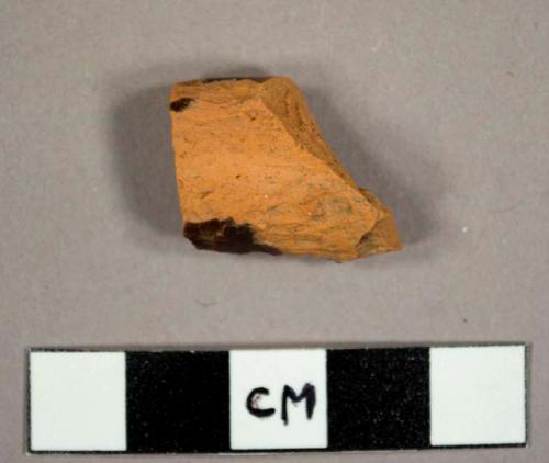 Red earthenware rim sherd to a pan with brown lead glaze on interior