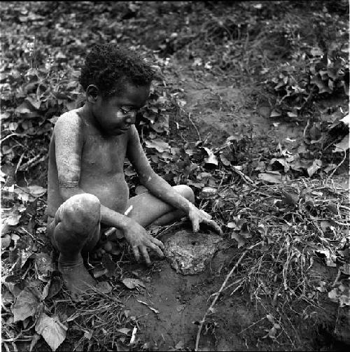 Tukom playing with mud