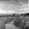 Woman crossing irrigation ditch