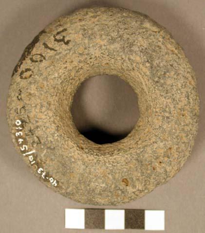 Stone ring. complete, discoidal. large hole in center (3.2 cm. dia.) wide shallo