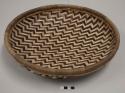 Basketry tray with alternating rows of light and dark zigzag pattern
