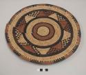 Coiled basketry plate; radiating brown and black design; alternating brown and black rim