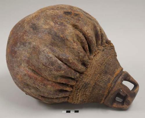 Liquid container; hide with woven plant fiber at shoulder and neck; carved wooden stopper