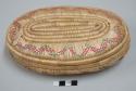 Covered oval-shaped basket; purple design on sides of bottom; red and green design on lid