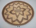 Basketry tray with dark center oval, two radiating zigzag circles, and rim