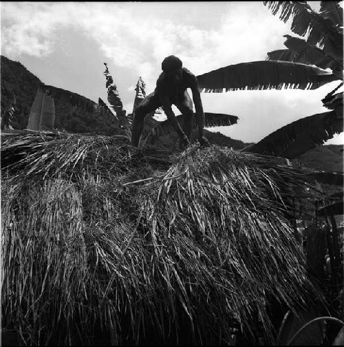 man thatching roof