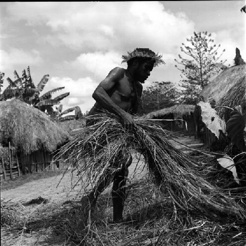 Man helping thatch roof