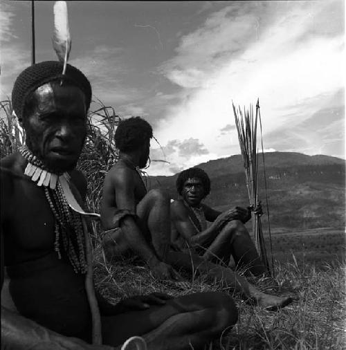 Weaklekek, Yegé Asuk, and another man sit on the Warabara