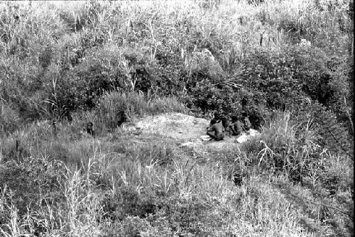 People sitting on the salt burning rock below the Tukumba