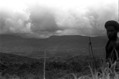 Looking towards the action in the elbow of the Warabara; man in the foreground looks at camera