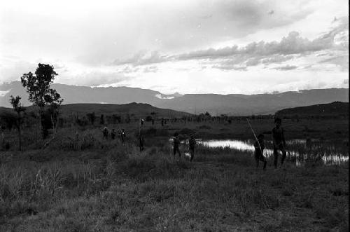 Men moving back past the pond on the Tokolik