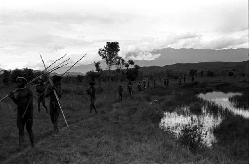 Men moving back past the pond on the Tokolik