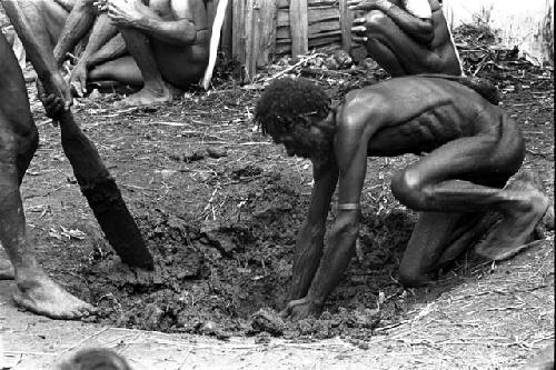 Men cleaning out the haksé (fire pit)