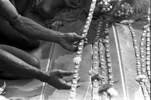 Cowrie bands of nyeraken aré being laid out on banana leaves