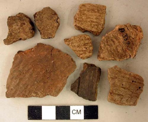 Coarse earthenware body and rim sherds, some undecorated, some cord impressed, some incised, some rocker dentate