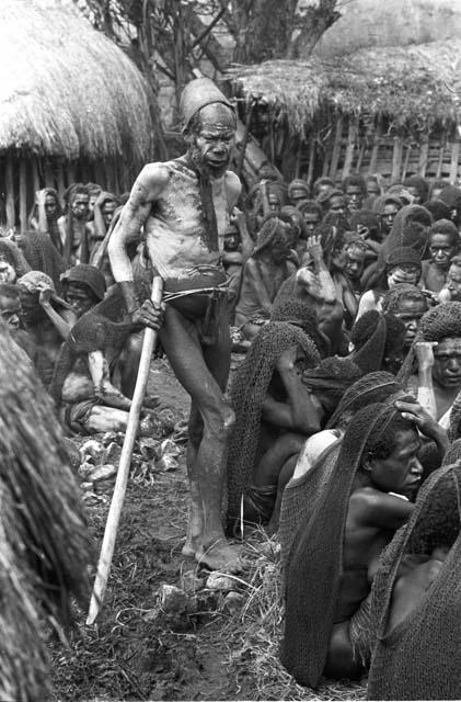 A male newcomer to the funeral, mourning amid the women's group