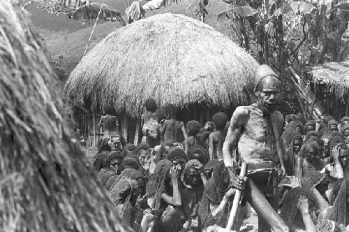 A male newcomer to the funeral, mourning amid the women's group