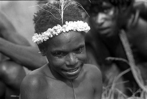 Child with flower garland on head at the Etai