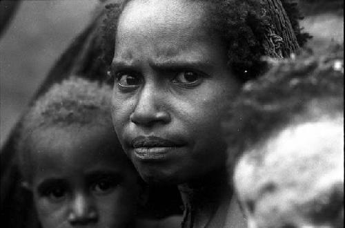 Women and children look towards the camera