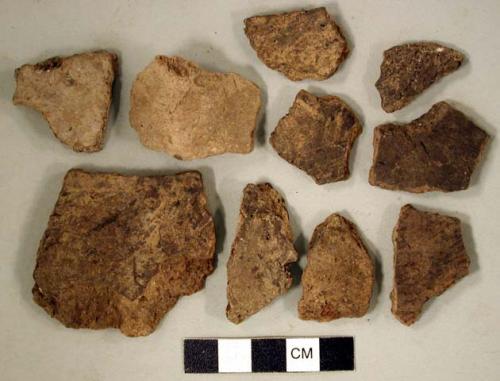 Coarse earthenware body and rim sherds, some cord impressed, some incised