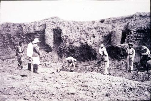 Men excavating next to a structure