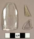 Colorless curved glass fragments, including a rim sherd to a faceted tumbler