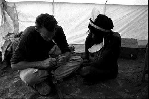 Robert Gardner in his tent with a Dani man