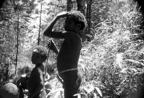 Boys standing among others clearing the ground