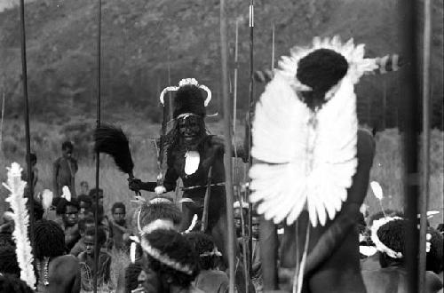 Men sing at an Etai; man dancing in center