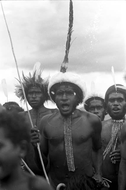 Close shot of men dancing at an Etai, spear in hand of central man