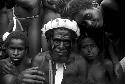 Young warriors, gathered around an adult warrior, look towards the camera at an Etai