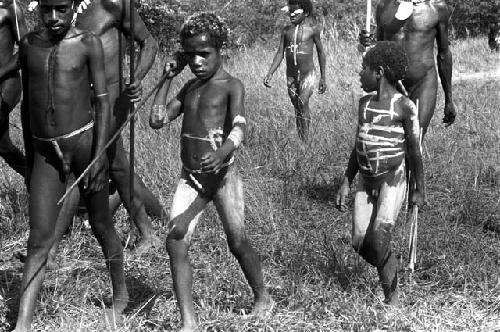 Boys decorated with clay, walking to sit down somewhere