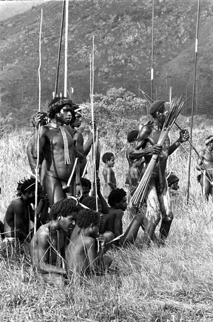 Warriors with spears and arrows watching others as they dance at an Etai