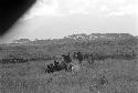 Distant shot of a women's group sitting among the grass at an Etai