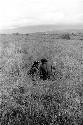 Men talk while seated in the grass