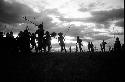 Dancing group of men silhouetted against the low sun