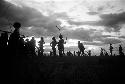 Dancing group of men silhouetted against the low sun