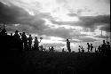 Dancing group of men silhouetted against the low sun