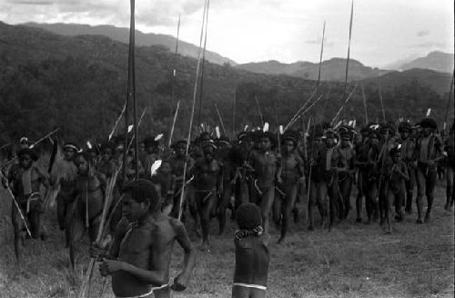 Group of men dancing at an Etai, spears sticking up around them