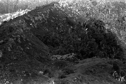 Distant view of a sili at the entrance to the salt well trail; hills surrounding the sili