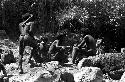 Group of men among the rocks above the salt well where women are working