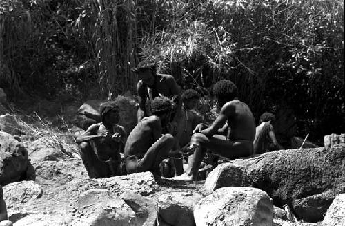 Group of men among the rocks above the salt well where women are working