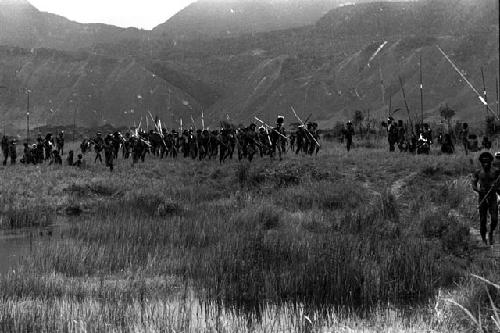 Large group of warriors running back from the battle front